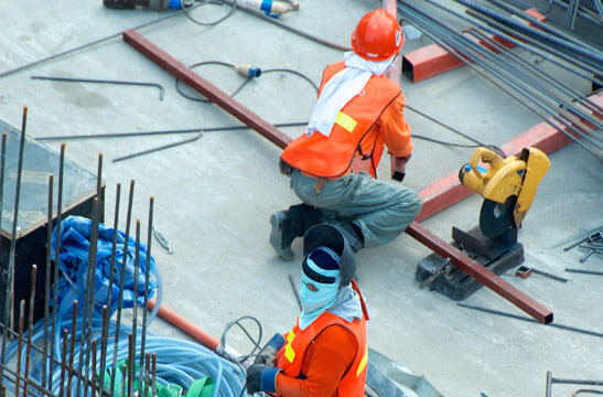 Workers in safety gear at a construction site.